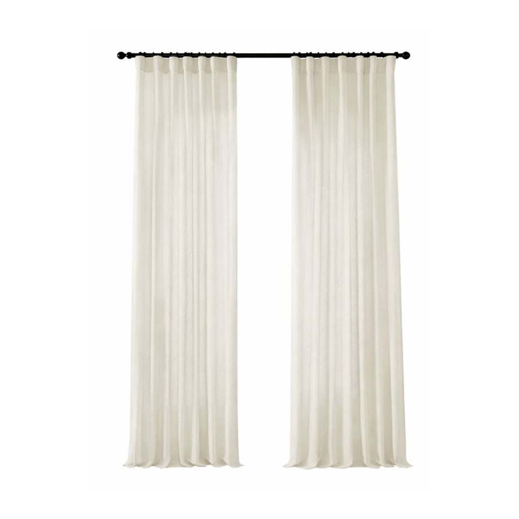 Cream curtain panels hanging on a black curtain rod demonstrating proper curtain height and drapery styling