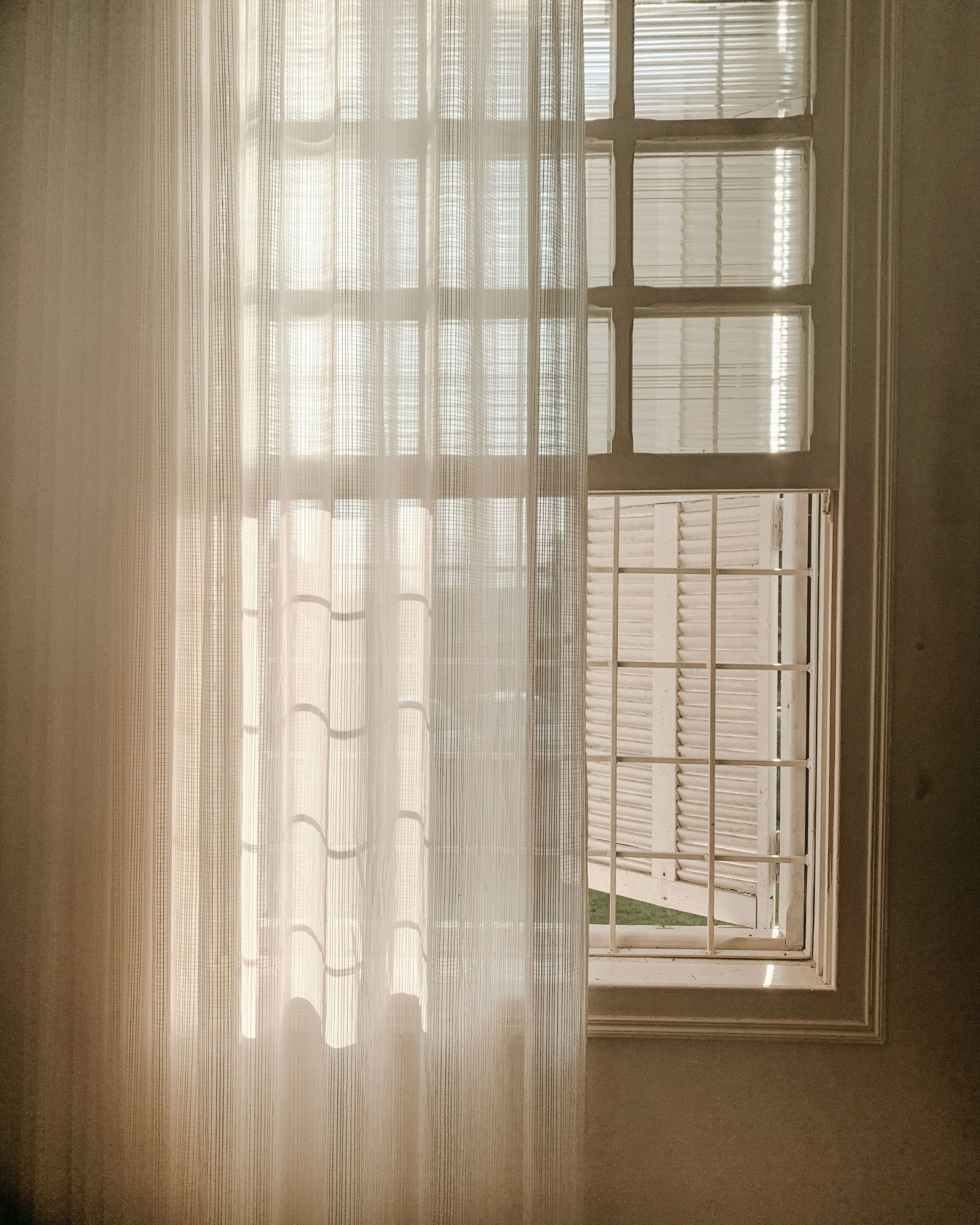 Sheer curtains hanging in front of a window showing soft drapery and natural light for elegant window treatment styling