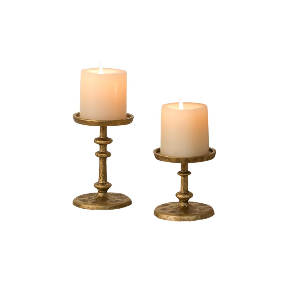 Aged brass candlesticks with pillar candles adding warmth and character to a historic coastal-inspired home.
