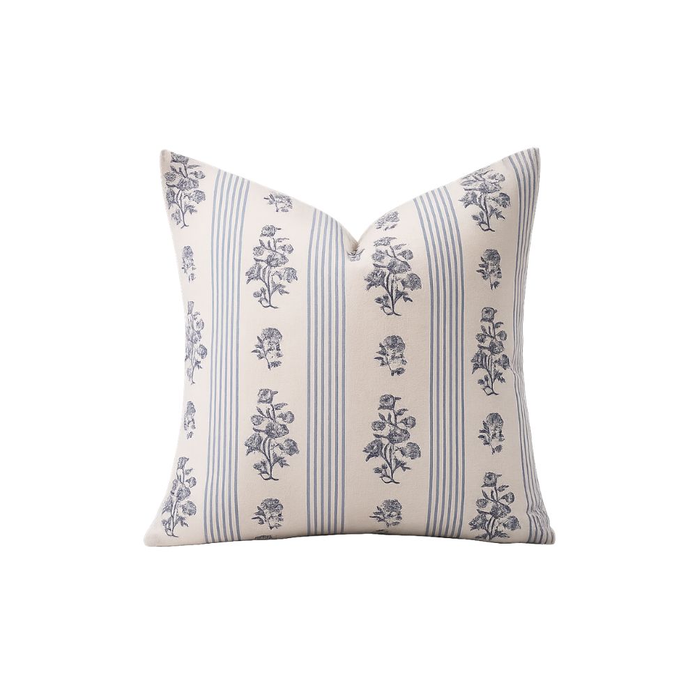 Decorative throw pillow featuring blue floral motifs and classic stripes inspired by historic coastal style.